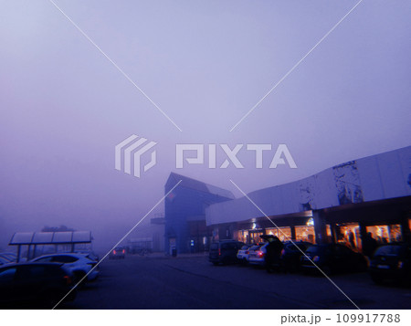 Shopping center at dusk with fog near Milan, Italy, in 2022. Shopping center at dusk with fog near Milan, Italy, in 2022. 109917788