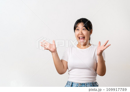 The pretty Asian young woman with surprise and shocked facial expression standing on a white background. 109917789