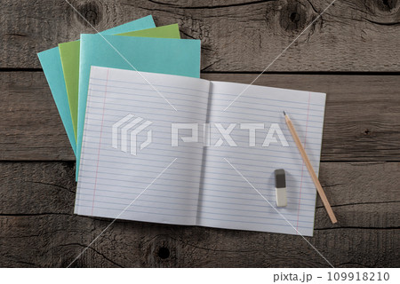 School Notebook with Lined Pages and Pencil with Eraser on Old Wooden Surface. File with Clipping Path. 109918210