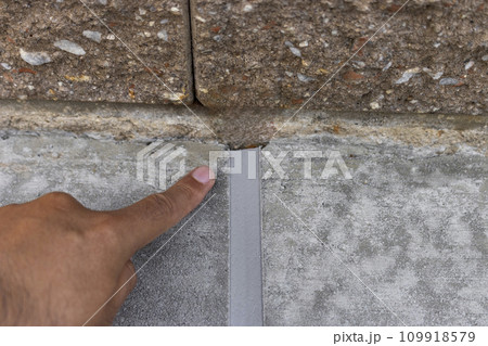 固まる前のコンクリートとブロック塀の境界 と男の手 109918579