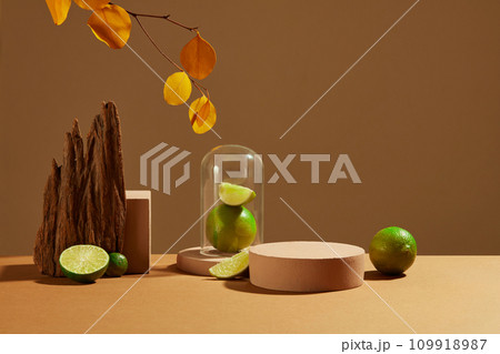 Fresh lemon and pink podium on brown background with autumn leaves and props. Lemon is an inexpensive natural cosmetic but is highly effective in exfoliating skin and treating acne. Fresh lemon and pink podium on brown background with autumn leaves and props. Lemon is an inexpensive natural cosmetic but is highly effective in exfoliating skin and treating acne. 109918987