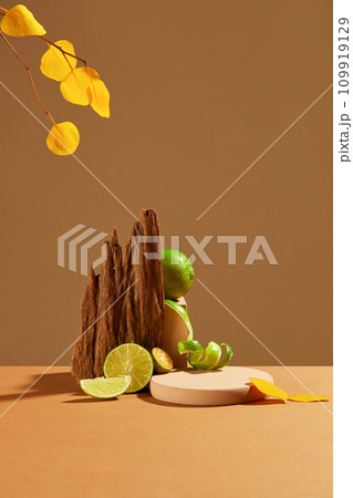 Fresh lemons are displayed on a brown background with a pink podium and dried wood. Blank space for product display. Lemon contains lots of vitamin C which is good for the skin. 109919129
