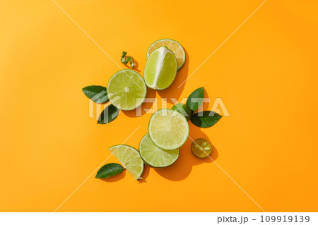 On a dark yellow background there are fresh lemons, kumquats and green leaves. Supplement vitamin C for the body from fresh fruits. Copy space for lemon-related product ads. 109919139