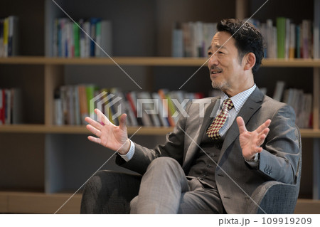 インタビューで手振りを使って説明しながら話すスーツを着たビジネスマン 社長や経営者や教授など インタビューで手振りを使って説明しながら話すスーツを着たビジネスマン 社長や経営者や教授など 109919209