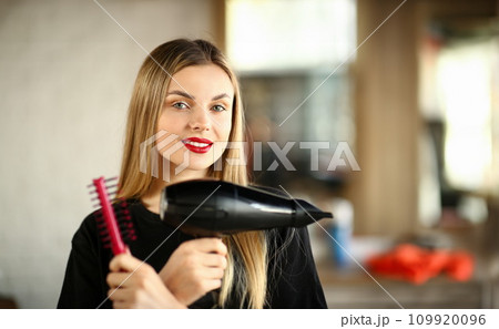 Girl Hairdresser Crossed Hands with Comb and Dryer Girl Hairdresser Crossed Hands with Comb and Dryer 109920096