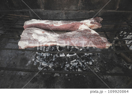 Raw meat put on the grill, traditional Argentine cuisine, Asado barbecue, Patagonia, Argentina. Raw meat put on the grill, traditional Argentine cuisine, Asado barbecue, Patagonia, Argentina. 109920864