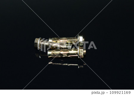 Anchor bolts made of brass on a dark background. Anchor bolts made of brass on a dark background. 109921169