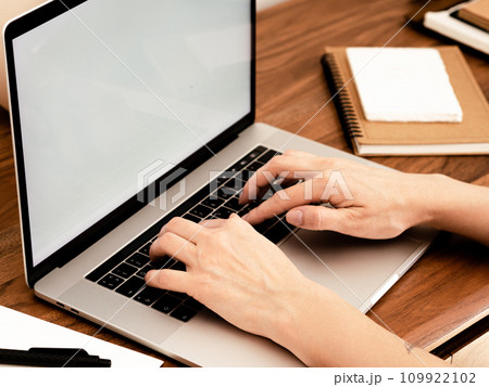 Unidentified woman working on a laptop at home Unidentified woman working on a laptop at home 109922102