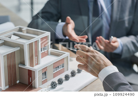 two successful people are discussing a house construction project. layout on the table 109924490
