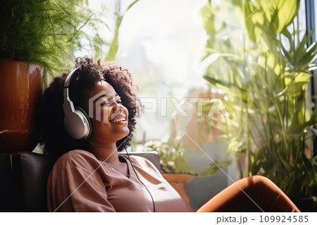 AI-generated content. Chubby young dark skinned women sits in relaxed posture listening music with headphones among plants 109924585