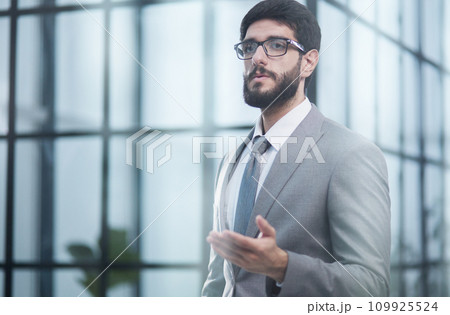 He stands near the office center, looks at the camera. 109925524