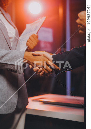 Team of software developers working on big project late at night in neon light trying to finish before deadline Team of software developers working on big project late at night in neon light trying to finish before deadline 109927144