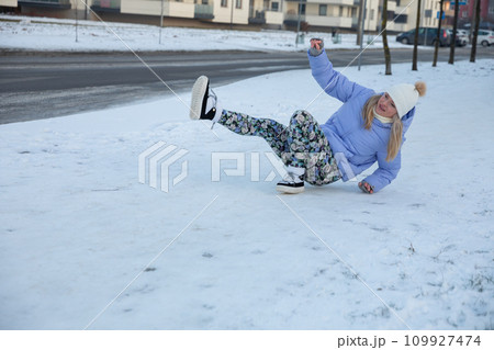 The girl slipped on an icy sidewalk in the city. 109927474