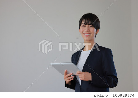 タブレットを持ち微笑むセミナー講師の女性1 109929974