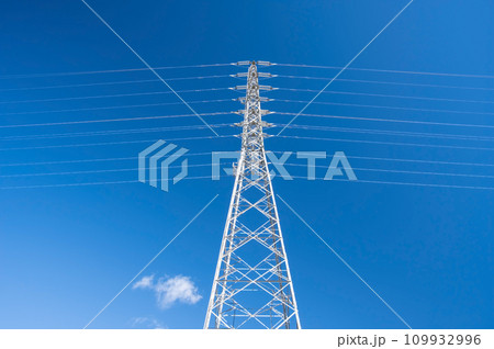 青空にそびえ立つ送電鉄塔 109932996