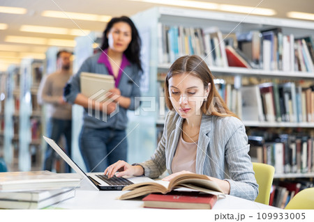 Girl student, studying on a laptop in the library 109933005