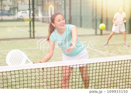 Young emotional women playing paddle tennis outdoors 109933150