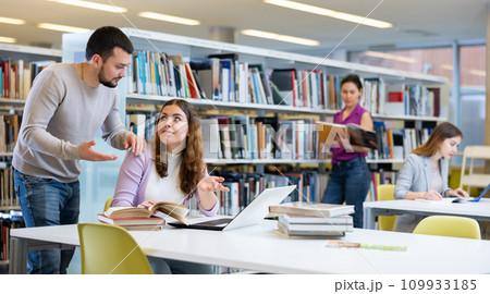 Woman and man studying together at library Woman and man studying together at library 109933185