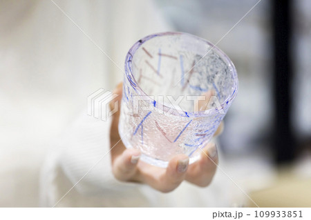 ガラス工房に売っているグラスを手に取る女性手元 109933851