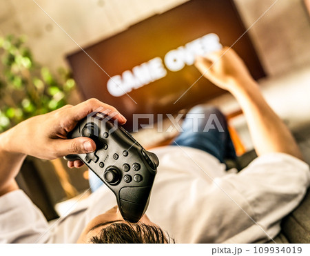 自宅でテレビゲームをする男性 109934019