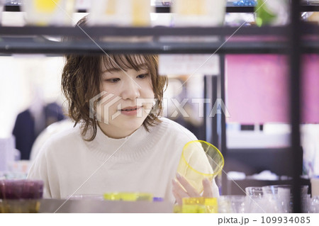 ガラス工房で買い物をする若い女性 109934085