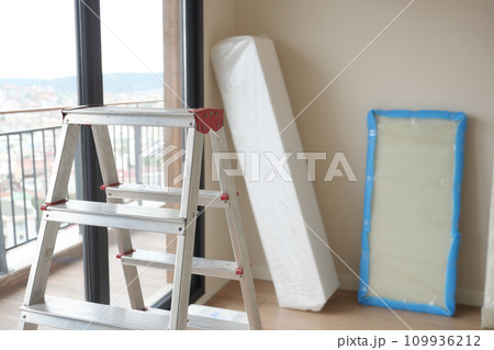 Metal ladder standing in empty room, renovation and improvement concept. Metal ladder standing in empty room, renovation and improvement concept. 109936212