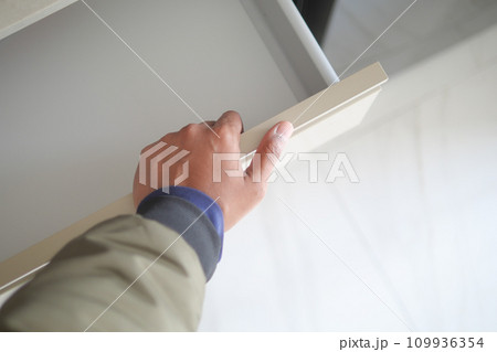 man's hand open drawer wooden in cabinet 109936354