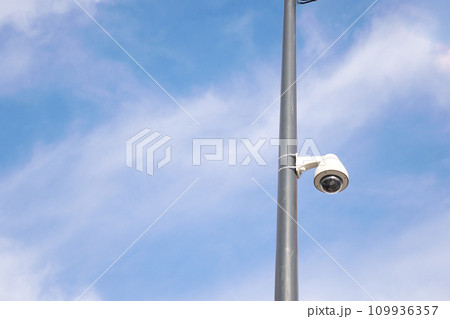 CCTV security camera operating outdoor against blue sky CCTV security camera operating outdoor against blue sky 109936357