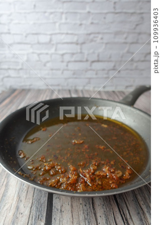 used cooking oil in frying pan. 109936403
