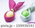Easter eggs and the shape of rabbit ears, on a white background, selective focus, tinted image 109936591
