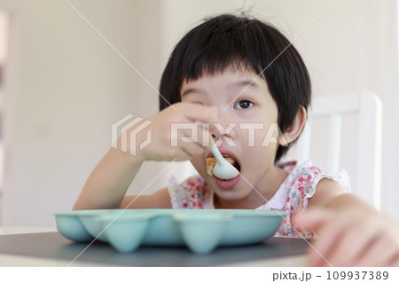 Little asian girl having breakfast Little asian girl having breakfast 109937389