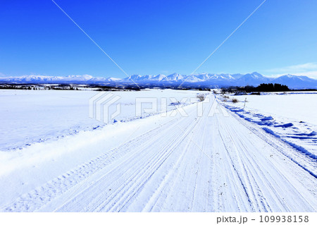 青空広がる冬の北海道の大地と雪道 青空広がる冬の北海道の大地と雪道 109938158