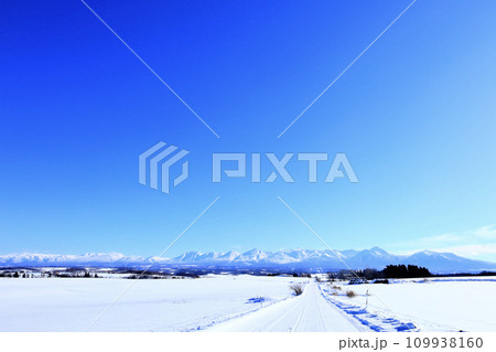 青空広がる冬の北海道の大地と雪道 青空広がる冬の北海道の大地と雪道 109938160