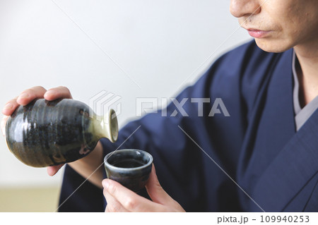 日本酒を飲む男性の手元 日本酒を飲む男性の手元 109940253
