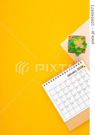Calendar page for January 2024 and houseplant on yellow background. 109940971