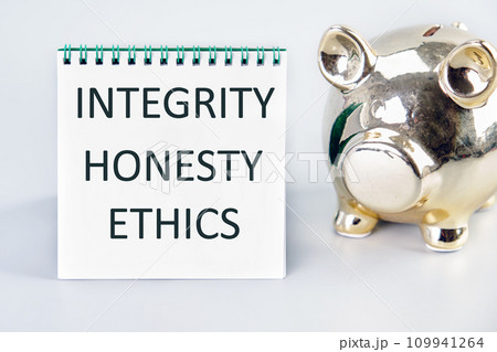 INTEGRITY HONESTY ETHICS A word, a text written on a white sheet next to a piggy bank 109941264