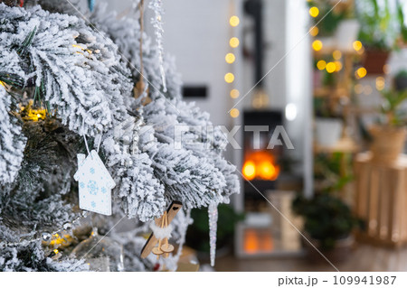 Key to the house with a keychain is hanging on the Christmas tree. A gift for New Year, Christmas. Building, design, project, moving to new house, mortgage, rent and purchase real estate. Copy space Key to the house with a keychain is hanging on the Christmas tree. A gift for New Year, Christmas. Building, design, project, moving to new house, mortgage, rent and purchase real estate. Copy space 109941987