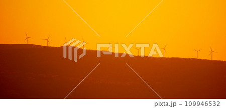 Silhouettes of wind power plant turbines on the ridge at sunset time Silhouettes of wind power plant turbines on the ridge at sunset time 109946532