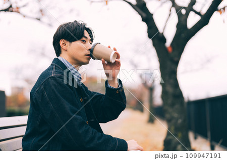 川沿いでコーヒーを飲む男性 109947191
