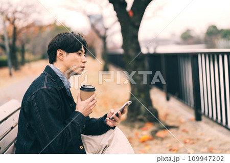 川沿いでコーヒーを飲む男性 川沿いでコーヒーを飲む男性 109947202