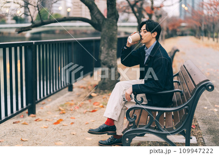 川沿いでコーヒーを飲む男性 109947222