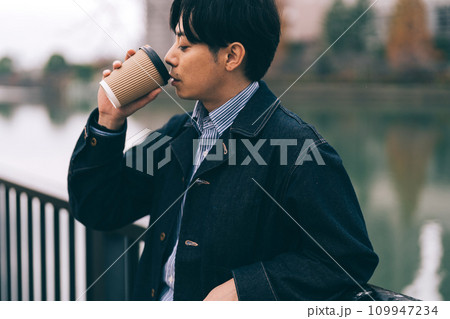 川沿いでコーヒーを飲む男性 109947234