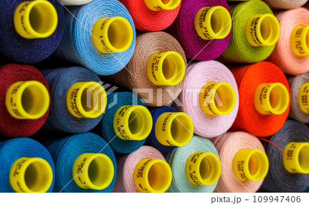 set of multi-colored spools of thread for sewing 109947406