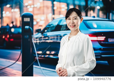 道路で電気自動車を充電する女性 109948776