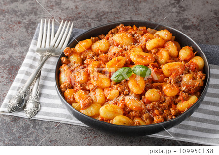 Italian potato gnocchi cooked with meat Bolognese sauce close-up in a plate. Horizontal Italian potato gnocchi cooked with meat Bolognese sauce close-up in a plate. Horizontal 109950138