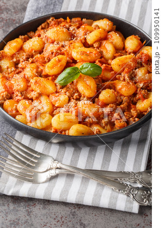Italian potato gnocchi with bolognese sauce closeup on the plate. Vertical 109950141