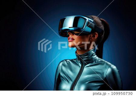 Young stylish woman wearing a modified commercial virtual reality headset on a blue background Young stylish woman wearing a modified commercial virtual reality headset on a blue background 109950730