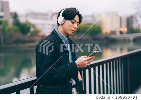 川沿いで音楽を聴く男性 109950791