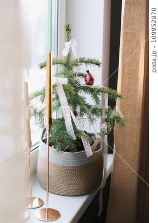 Interior design with christmas tree and candles. Home decor. New Year lace decorations for the Christmas tree in eco style. Holiday Template with Christmas decorations on fir tree. Interior design with christmas tree and candles. Home decor. New Year lace decorations for the Christmas tree in eco style. Holiday Template with Christmas decorations on fir tree. 109952870