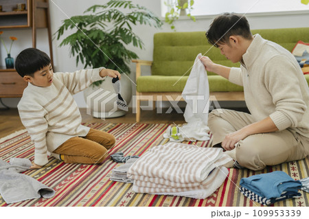 洗濯物をたたむ親子 30代の父親と7歳の男の子 洗濯物をたたむ親子 30代の父親と7歳の男の子 109953339
